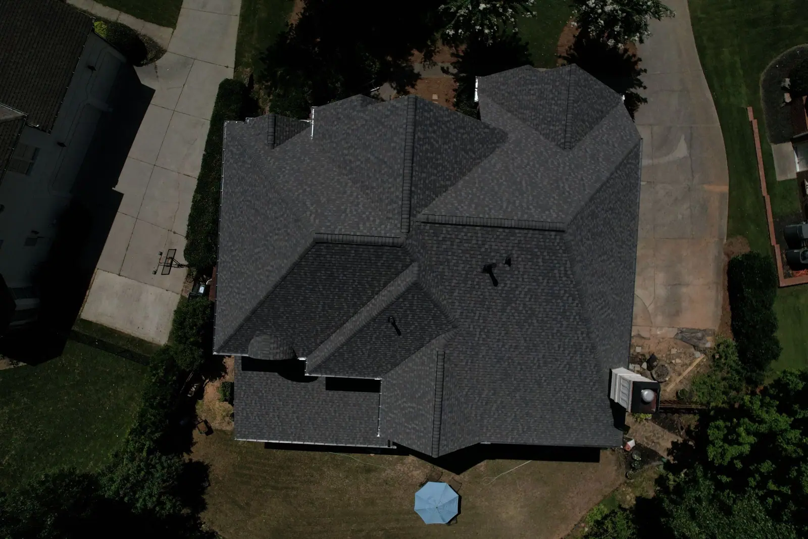 Top-down photo of a finished charcoal hip roof with clean valleys, a Dryco Roofing job