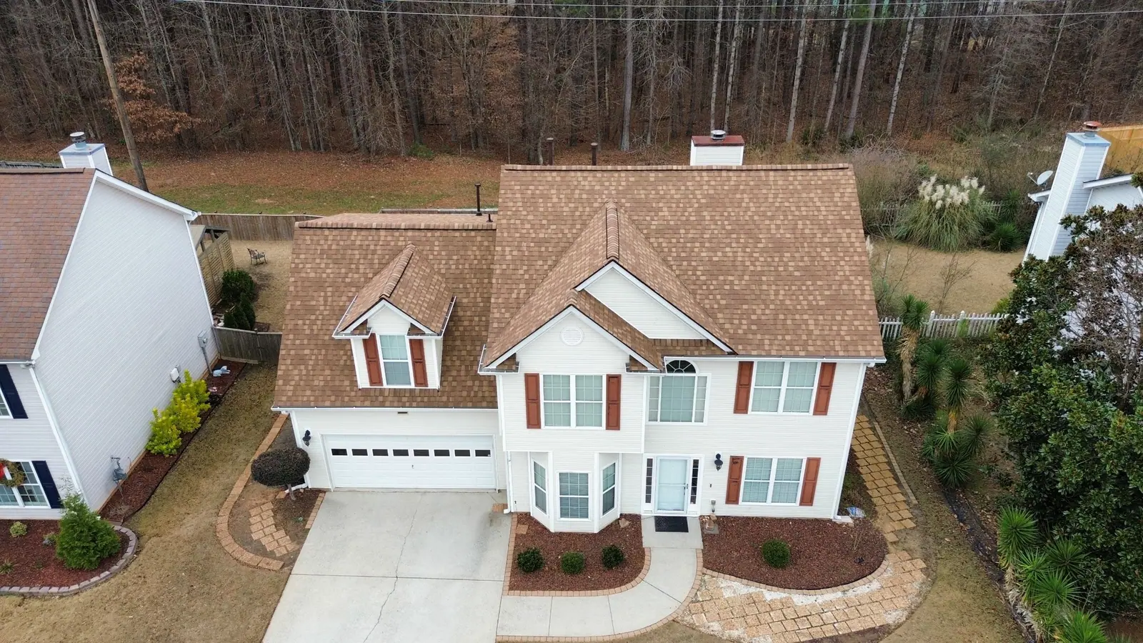 View of a two-storey home with a new brown architectural shingle roof by Dryco Roofing