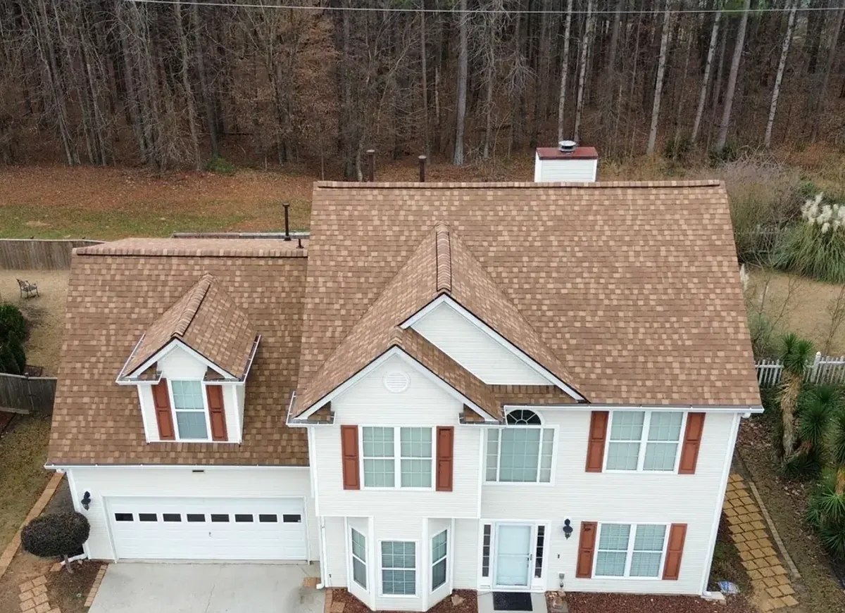 The same two-storey home with a new brown architectural shingle roof by Dryco Roofing