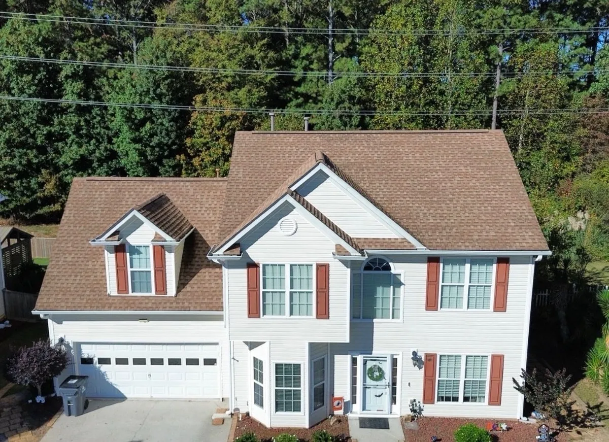 A two-storey home before Dryco Roofing replaced its worn shingle roof